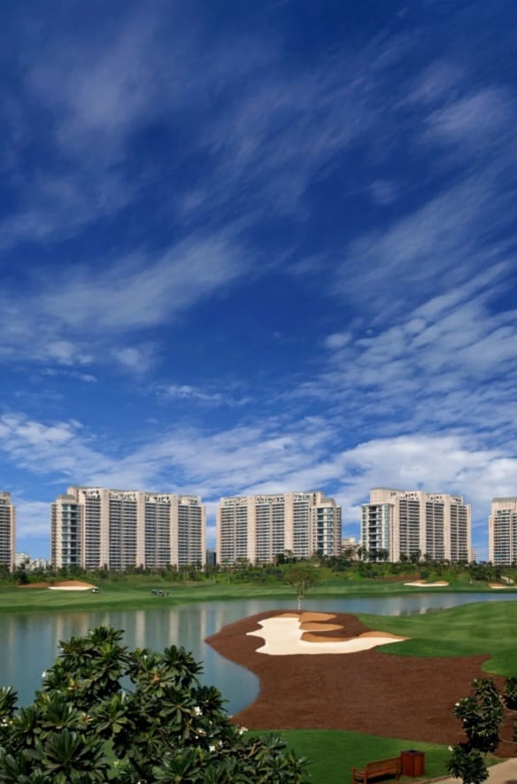 DLF The Magnolias towers seen across water and golf greens