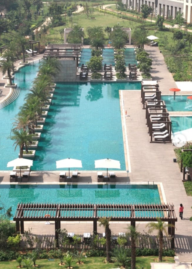 Swimming pool and poolside seating at DLF The Magnolias